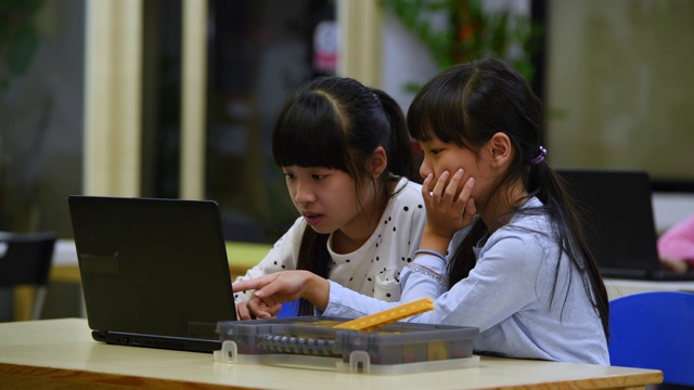 两个小女孩在学校用笔记本电脑学习编程视频素材