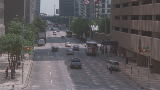 潘上敞篷车，可以是大众甲壳虫，在市中心的城市街道上行驶，在汽车之间穿梭。摩天大楼或高层办公大楼。汽车特技表演。人行道上的人或行人。视频素材