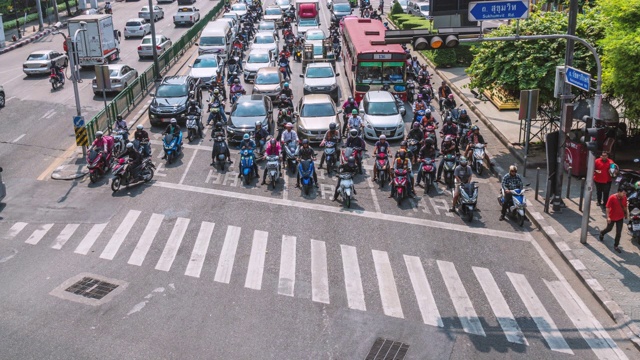 4K时间推移鸟瞰图的道路与交通堵塞和拥挤的匿名的人行人十字路口人行横道在曼谷高峰时间，交通和乘客旅行的概念视频素材