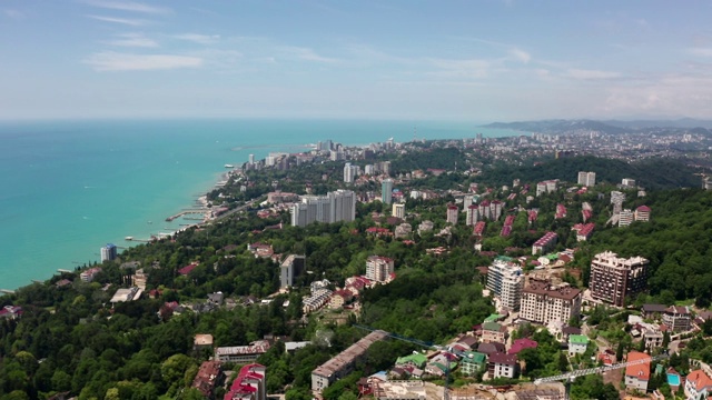 航拍视频拍摄。在住宅区上空飞行。索契的城市度假胜地。黑海海岸。绿林临海，山川临海。视频素材