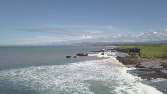 海浪拍打着岩石海岸靠近印度教塔纳寺，印度尼西亚巴厘岛视频素材