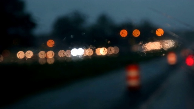 大雨落下的夜晚，汽车模糊，夜路模糊。视频素材