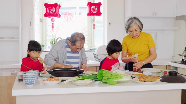 中国一家几代人在厨房里准备新年食物视频素材