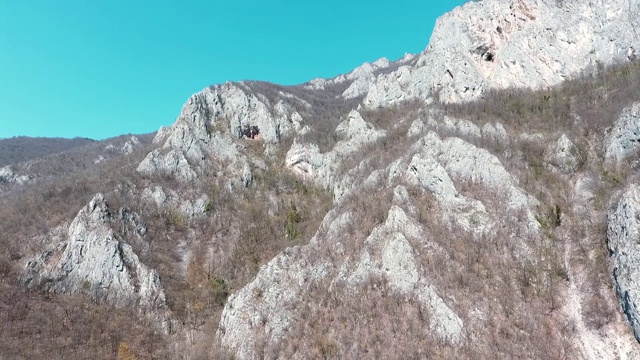 鸟瞰图的岩石石灰岩山脉在西莫拉瓦河塞尔维亚峡谷与树木和蓝天之上视频素材