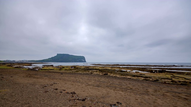 韩国济州岛的光芝木海滩和Seongsan Ilchulbong山(以美丽的日出景色而闻名)的白天到晚上的景色视频素材