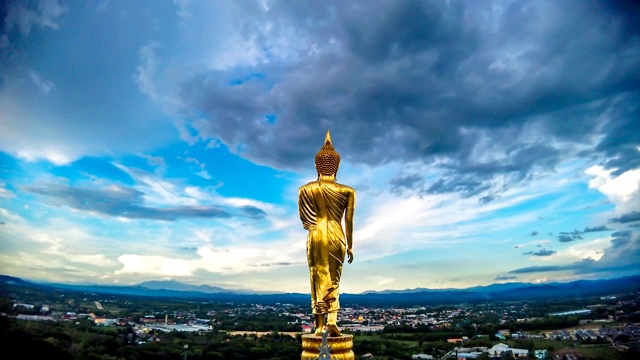 Time-lapse golden buddha statue with cloudy sky and city at Wat Phra That Kao Noi, Nan, northern of Thailand - Stock video…保存视频素材