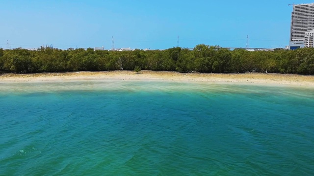 热带令人放松的海滩和蓝色海洋后面的小森林视频下载