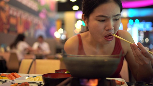 年轻女子正在吃日本食物。视频素材