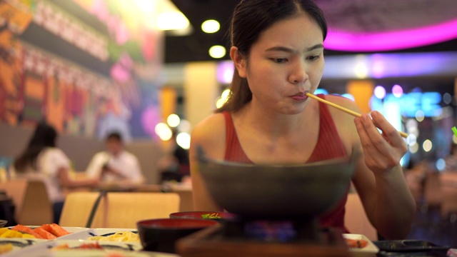 年轻女子正在吃日本食物。视频素材