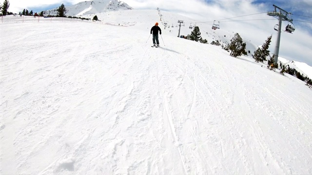 滑雪者在高山滑雪胜地的雪道上骑行，正面，慢动作视频素材