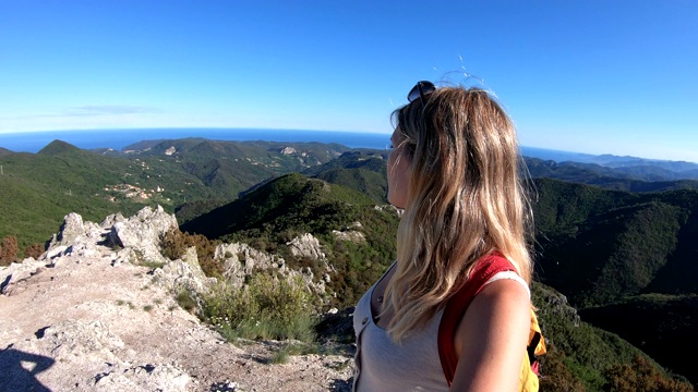 一位女性徒步旅行者在山顶停下来视频素材