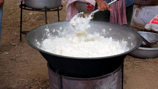 一名男子用金属铲在锅里翻炒米饭视频素材