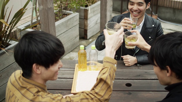 年轻的日本男人在户外餐桌上敬酒和喝酒视频素材