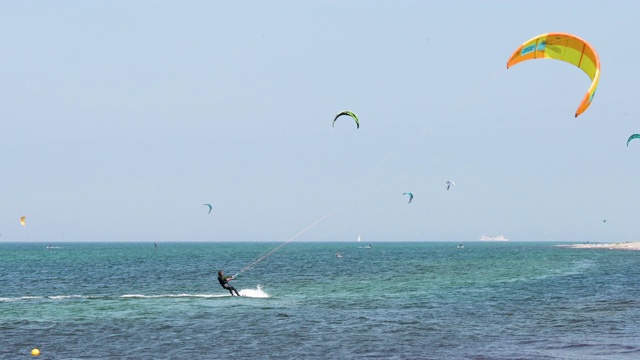 风筝冲浪者在海里，在海滩上玩着抢风和抢浪视频素材