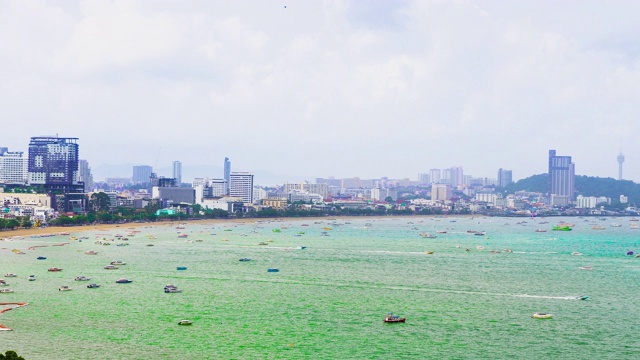 白天，芭堤雅的海岸线、海滩、海面上漂浮着的船只和摩天大楼。视频素材