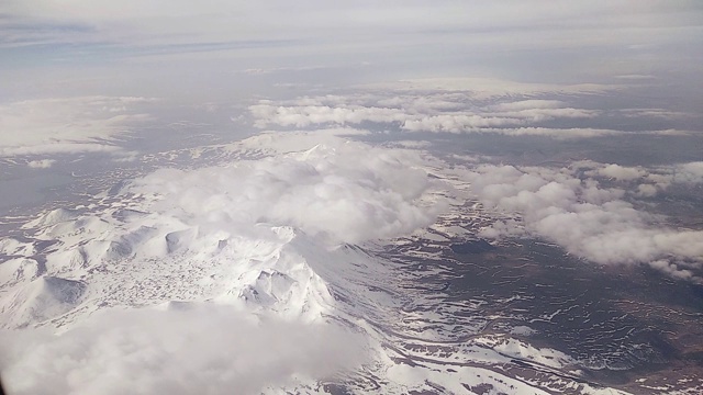 从飞机的舷窗可以看到云和雪山视频素材