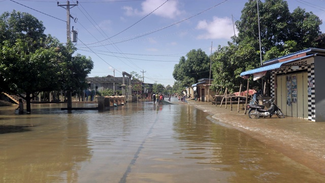 在农村地区，人们走在被洪水淹没的街道上视频素材