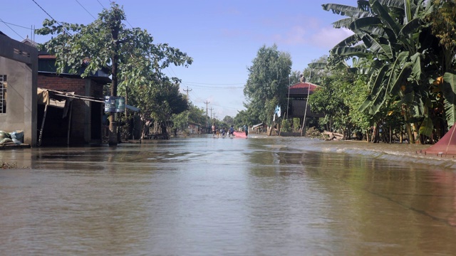 乡村地区被水淹没的道路的地面视图。人们走下来作为背景视频素材