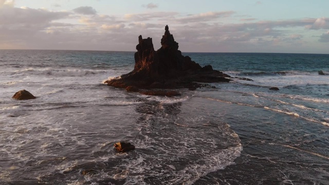 海洋中一块孤立岩石的鸟瞰图。大西洋黑色火山沙滩。本尼霍海滩，特内里费，加那利群岛，西班牙视频素材