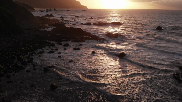 特内里费岛北部海岸美丽的日落，海滩上有巨大的石头和黑色的沙子。从以上观点。视频素材