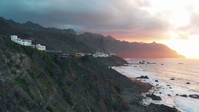 日落时长长的海岸线鸟瞰图:悬崖和大西洋，黑色火山沙的海滩和五颜六色的小城市，特内里费，西班牙视频素材