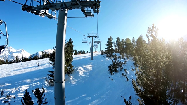 冬季高山滑雪胜地。雪林和滑雪者在滑雪缆车pov。鸟瞰图视频素材