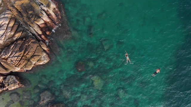 一对夫妇浮潜周围的珊瑚礁在海里视频素材