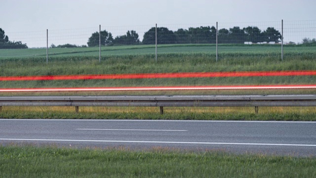 高速公路或高速公路上快速行驶的汽车的轻尾。从白天到夜晚的时间流逝。视频素材