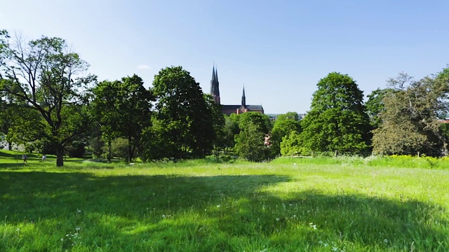 美丽的绿色城市景观，著名的大教堂塔顶在蓝天的背景。Europe.Sweden。乌普萨拉。视频素材