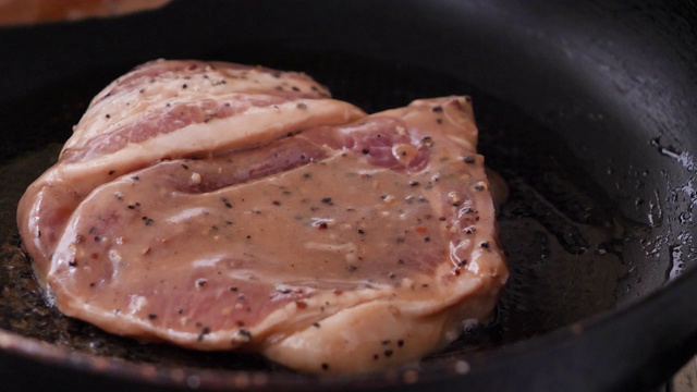 特写在热锅里烤猪肉牛排视频素材