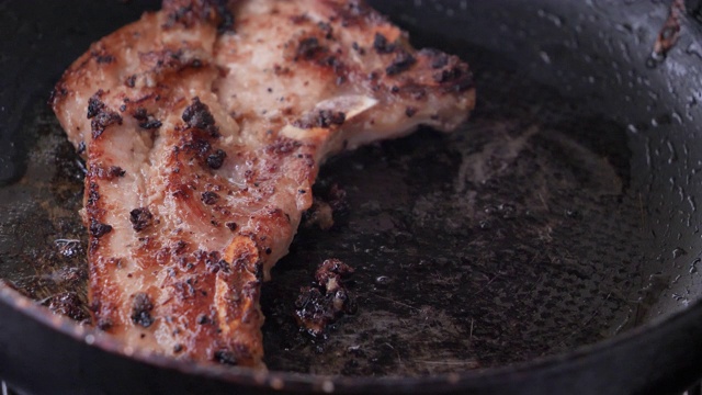 特写在热锅里烤猪肉牛排视频素材