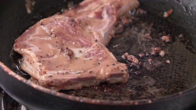 特写在热锅里烤猪肉牛排视频素材