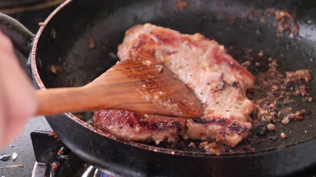 特写在热锅里烤猪肉牛排视频素材