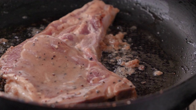 特写在热锅里烤猪肉牛排视频素材