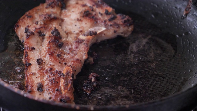 特写在热锅里烤猪肉牛排视频素材