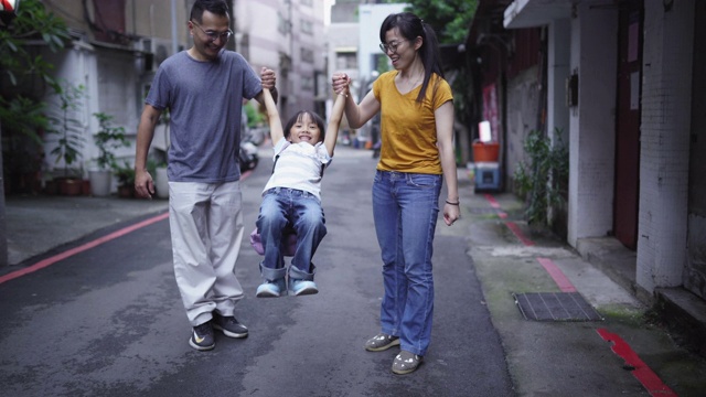 小女孩和父母一起走在上学的路上视频素材