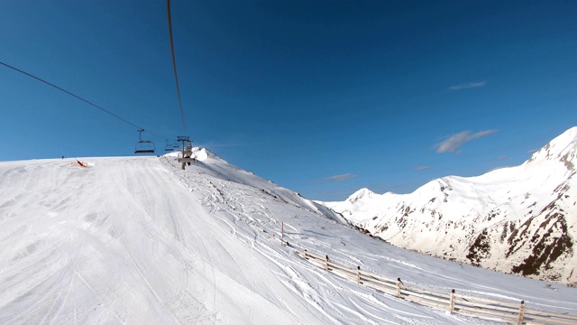 从滑雪缆车到滑雪道的鸟瞰图，以及滑雪者快速滑下滑雪道的画面视频素材