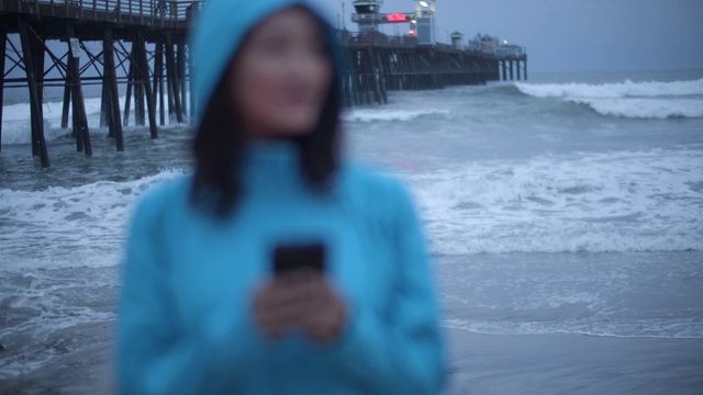 一名年轻女子在暴风雨中使用手机视频素材