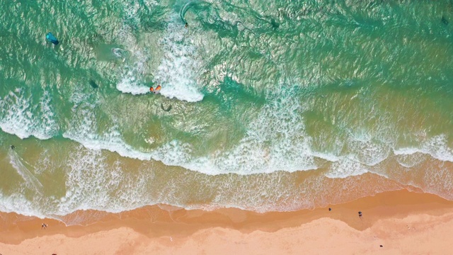 鸟瞰图。浪花在白色的沙滩上拍打。海浪拍打着美丽的海滩视频素材