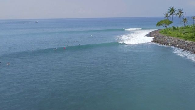 冲浪者冲浪板上的蓝色海浪在热带度假鸟瞰。在印尼巴厘岛的海上冲浪。水的运动。极限运动。夏天的活动视频素材