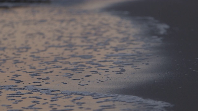 黄昏时，浪花拍打着海滩视频素材