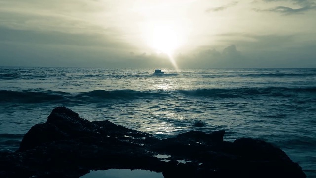 梦幻的颜色夕阳照耀海浪在岩石海滩风景在巴图博龙海滩视频素材