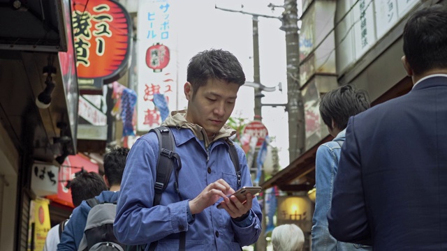 一名日本男子在东京看手机寻求指引的慢动作视频视频素材