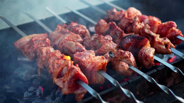 烤肉架上的烤肉串的特写镜头。烧烤。烤猪肉或羊肉。视频素材