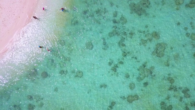 鸟瞰图美丽的曲线海滩与旅客放松与翡翠海。视频素材