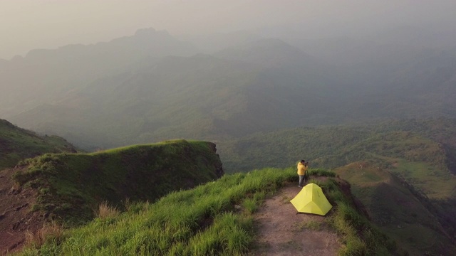 4k分辨率鸟瞰图的旅游摄影师露营和帐篷的悬崖和美丽的山，在Phu Tubberk泰国旅游冒险概念视频素材