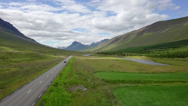 空中美丽的风景周围的山在冰岛北部，在冰岛北部的道路旅行上的观车，假日公路旅行的概念是时刻放松，在冰岛公路旅行视频素材