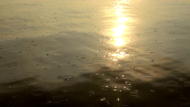 日落时雨滴落在海洋上的特写镜头视频素材