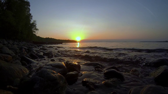 日落时湖岸上的波浪视频素材