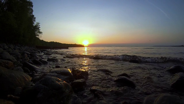 日落时湖岸上的波浪视频素材